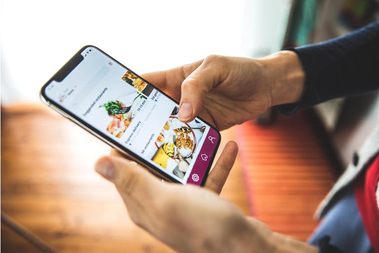 Woman ordering food by mobile app delivery at home at social distancing time